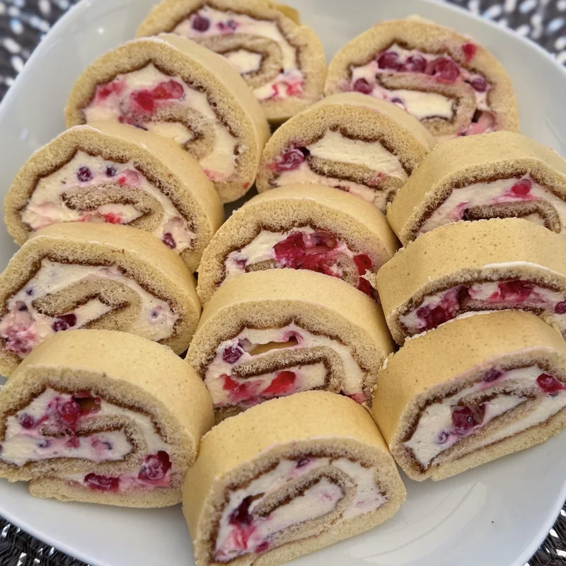 Biskuitrolle mit Mascarponecreme und Johannisbeeren, fertiges Gericht auf dem Hauptfoto